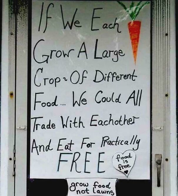 Sign advocating growing food to trade and eat for free, expressing anti-capitalism views on living life without pay walls.