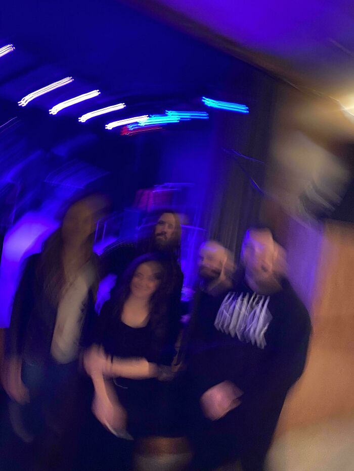 Blurred group photo under blue lights showing mildly infuriated people sharing moments that ruined their mood.