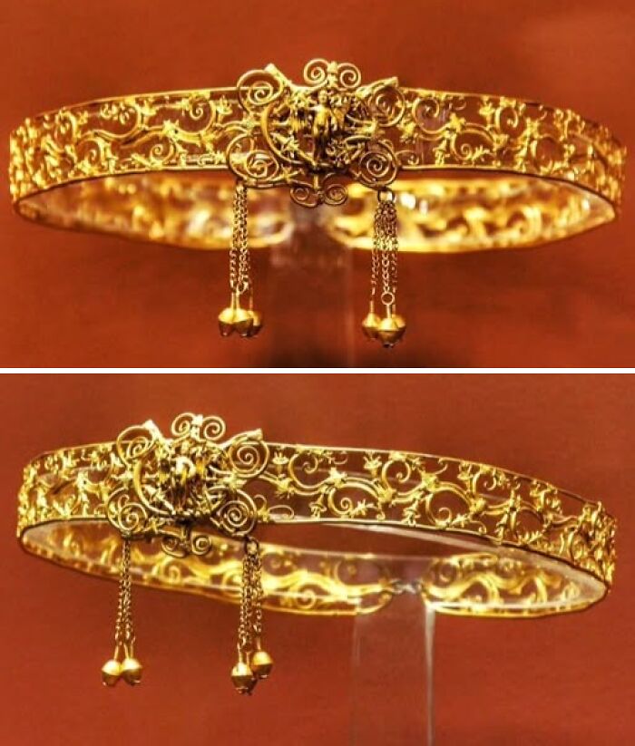 Ornate ancient golden crown with intricate scrollwork and dangling bells displayed in archeology and art exhibit.