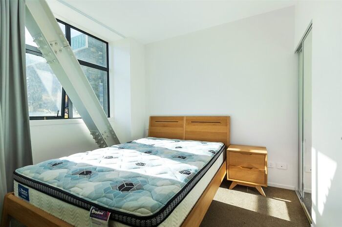 Bedroom with mattress and wooden furniture highlighting dumb interior design decisions and common sense errors in decor.