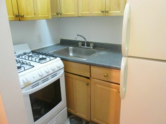Tiny kitchen with poorly planned layout, stove and sink positioned too closely, illustrating dumb interior design decisions.