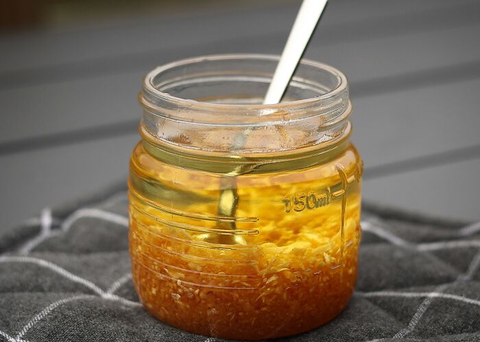 Glass jar filled with raw garlic in oil, illustrating common foods that go bad more quickly than expected.