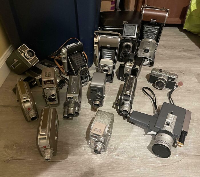 Collection of vintage cameras and camcorders displayed on a wooden floor, showcasing unusual collections in homes.