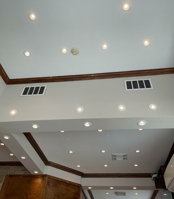 Multiple ceiling lights installed in a room with wooden trims showing a dumb interior design decision.