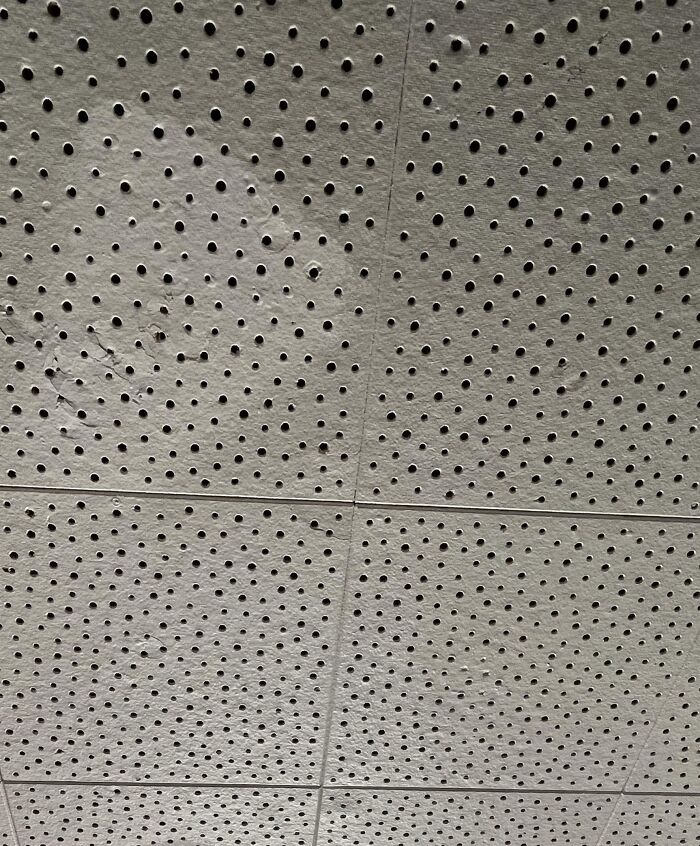 Perforated ceiling tiles with uneven spacing highlighting dumb interior design decisions and lack of common sense.