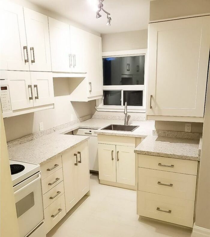 Small kitchen with white cabinets and countertops showing dumb interior design decisions lacking common sense.