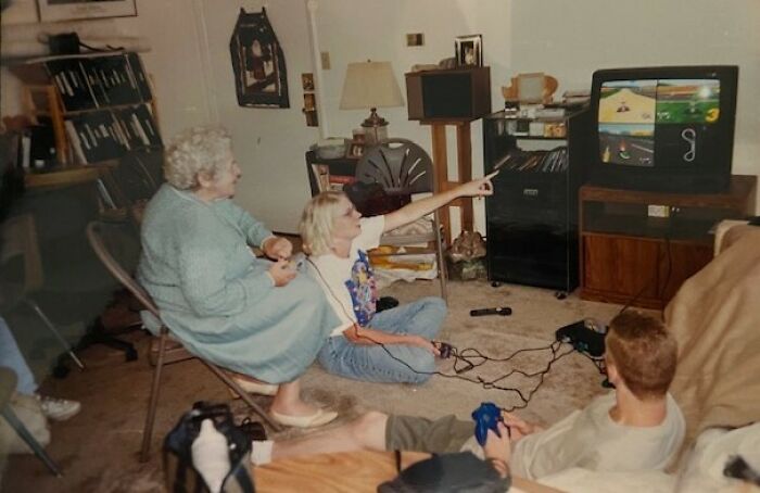 Three people playing video games in a living room, capturing a moment from people-share-found-photos.