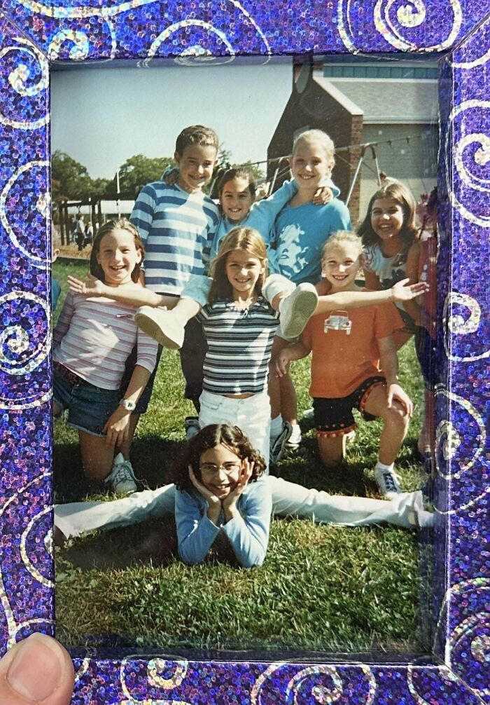 Group of kids posing outdoors in a playful scene, captured in a shared nostalgic photo frame with vibrant purple swirls.