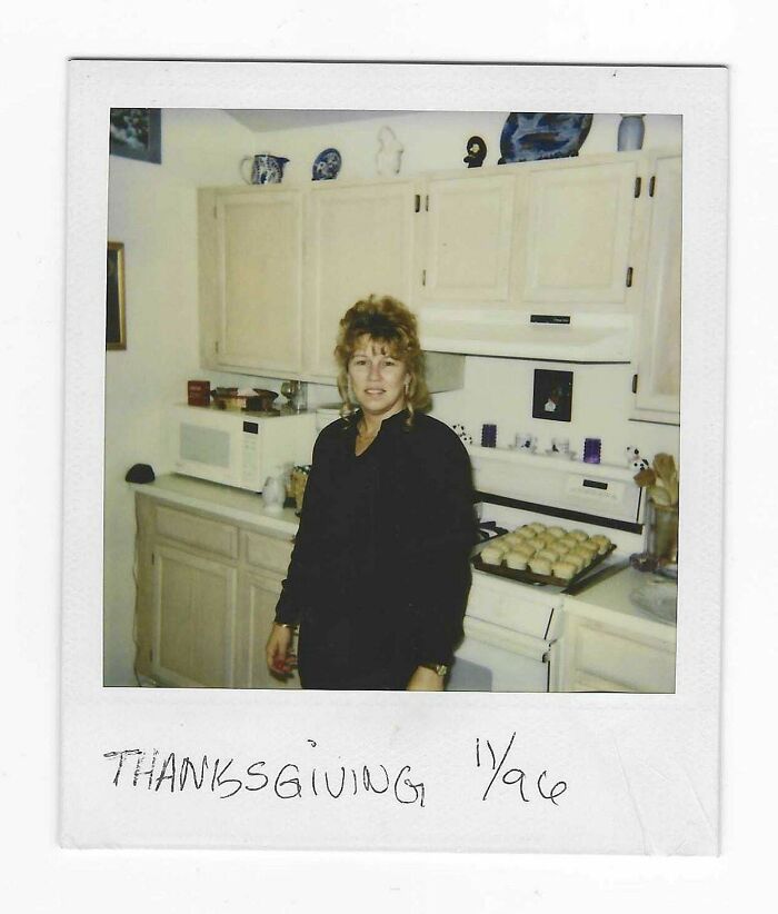 Woman standing in kitchen with baked rolls on stove, smiling for a people-share-found-photos moment on Thanksgiving.