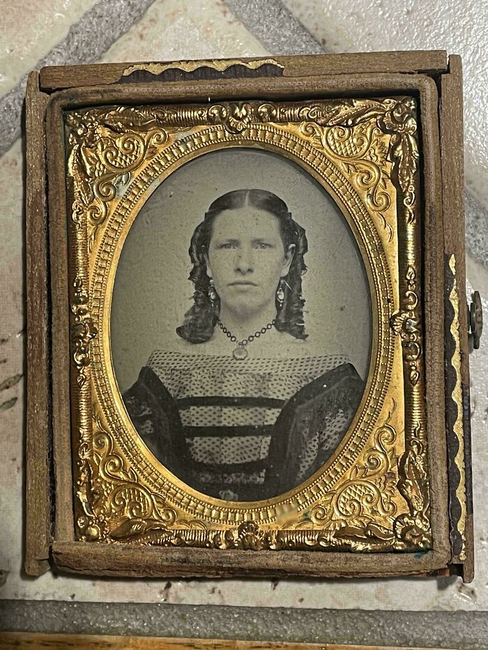 Antique framed portrait of a woman with curled hair, shared by people in found photos collection.