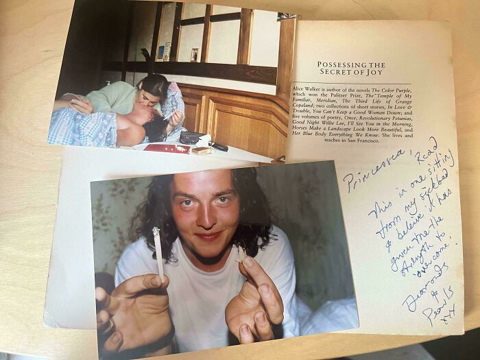 Two found photos on a wooden table showing a couple and a person holding torn cigarettes, people share found photos.