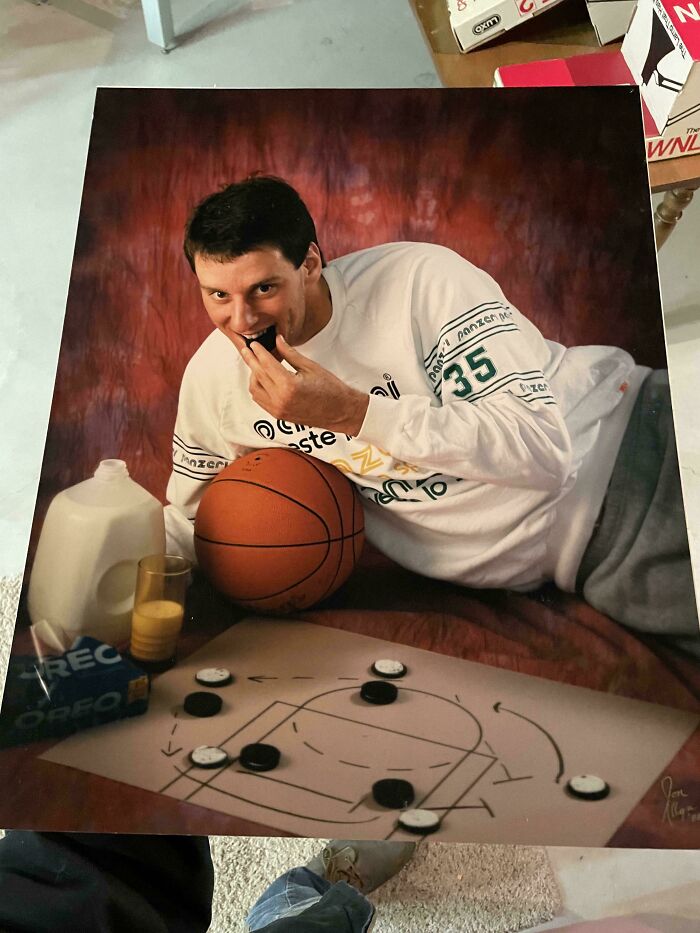 Man laying on floor with basketball, eating Oreos near milk and a basketball court strategy diagram in found photos.