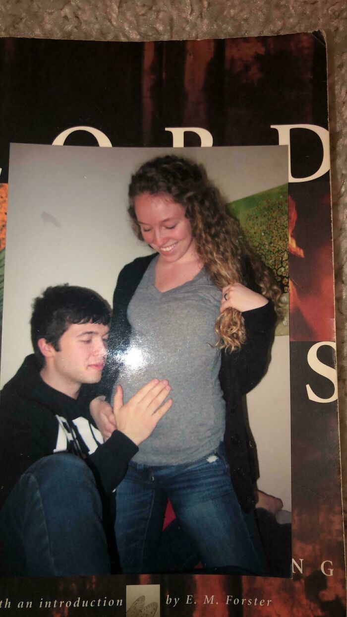 Young couple sharing a joyful moment with man touching woman’s belly in a candid people-share-found photos snapshot