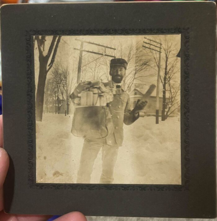 Vintage black and white photo of a man holding packages outdoors in a snowy scene, people share found photos.