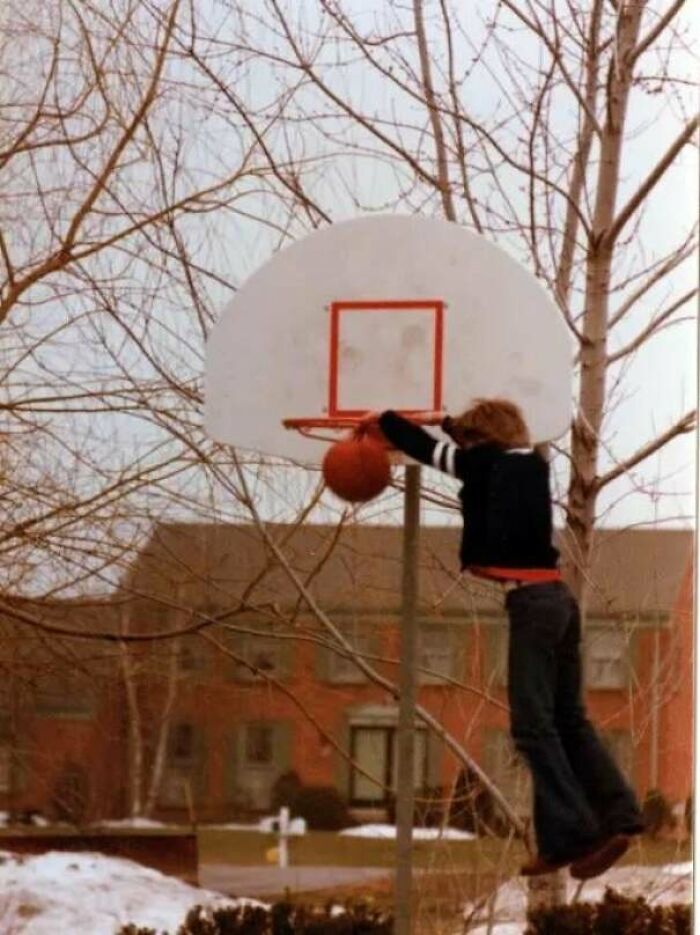 Child attempting to dunk a basketball on an outdoor hoop, one of the people share found photos capturing candid moments.