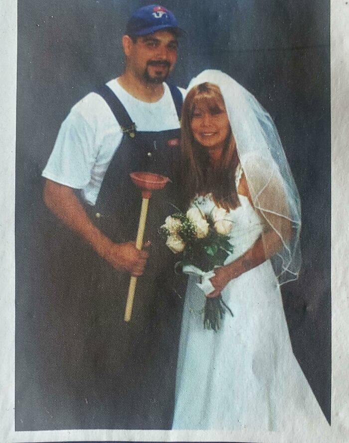 Couple posing in wedding attire with the groom holding a plunger, a unique found photo shared by people.