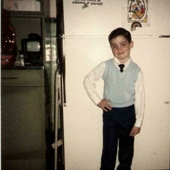 Young boy posing in vintage kitchen, sharing a found photo that captures a nostalgic moment from the past.