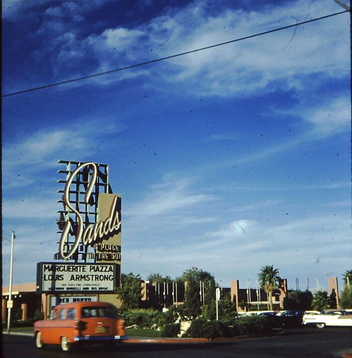 Vintage photo showing a Sands hotel sign with cars driving by on a clear sunny day, people share found photos.