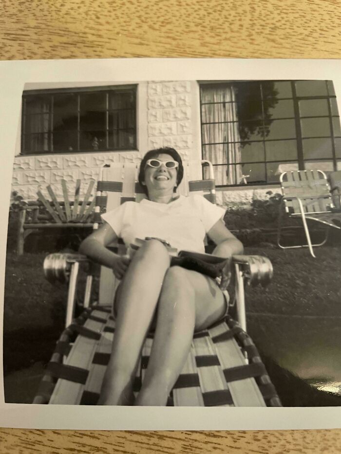 Woman relaxing on a lounge chair outdoors in a vintage black and white photo from a people-share-found-photos collection.