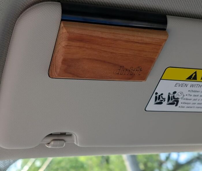 Wooden sun visor organizer attached to car roof, showcasing a popular Amazon movers and shakers trending product.