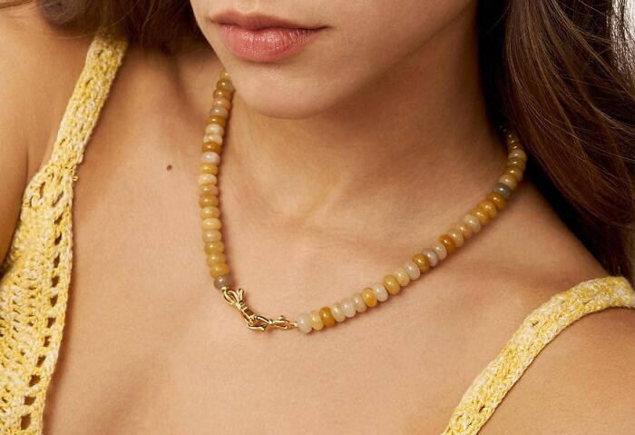 Close-up of a woman wearing a beaded necklace with yellow tones, showcasing popular Amazon movers and shakers jewelry trends.