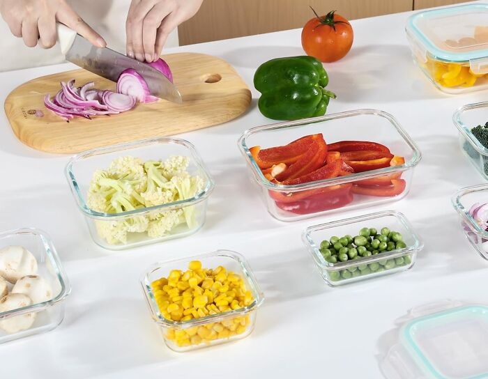 Person slicing red onion on a cutting board with glass containers of fresh vegetables, popular Amazon movers and shakers.