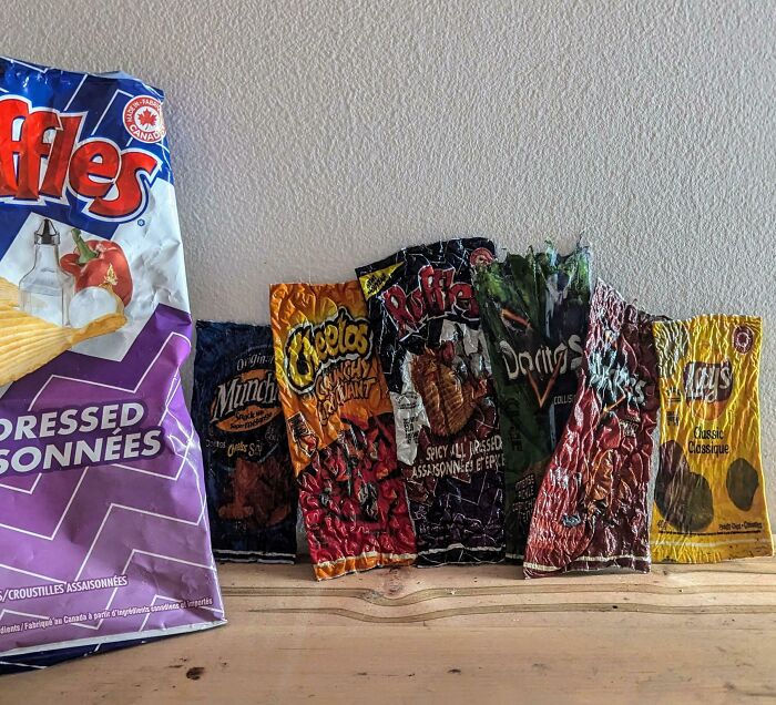 Collection of crumpled and dried chip bags displayed as an unusual collection in a home setting.