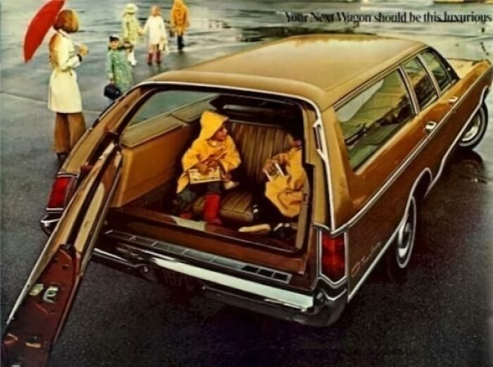 Children in raincoats sitting in the back of a vintage station wagon in a nostalgic outdoor scene.