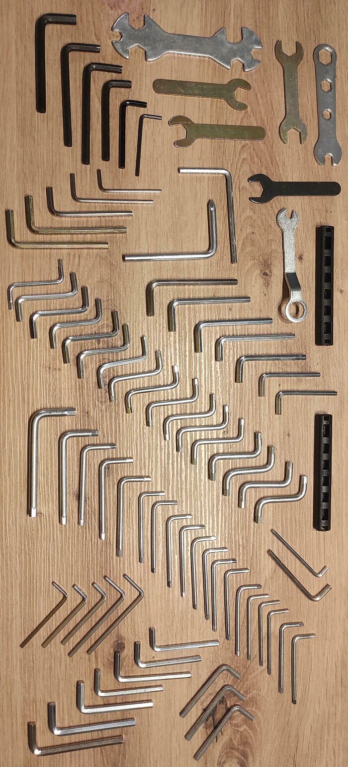 Collection of various unusual and interesting hex keys and wrenches neatly arranged on a wooden surface.