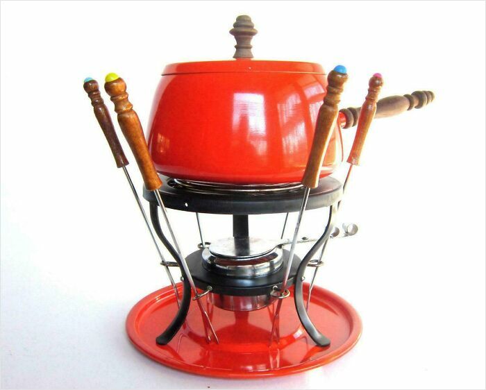 Vintage red fondue pot set with wooden-handled forks, a nostalgic photo that might make you say heck I'm old.
