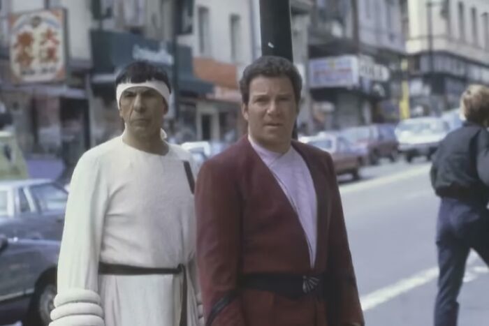 Vintage nostalgic photo of two men dressed in classic 1980s costumes on a city street scene