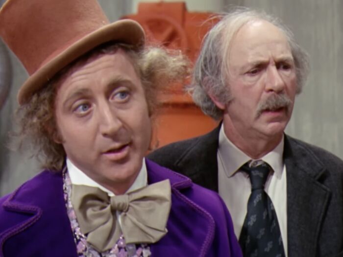 Actors in classic nostalgic photos dressed as W***y Wonka and an elderly man from a vintage film scene, evoking old memories.