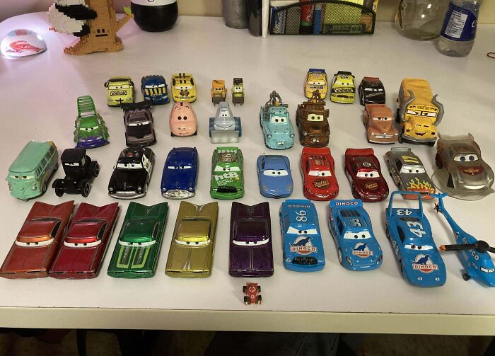 Collection of unusual toy car models from the Cars movies displayed on a white tabletop in a home collection.