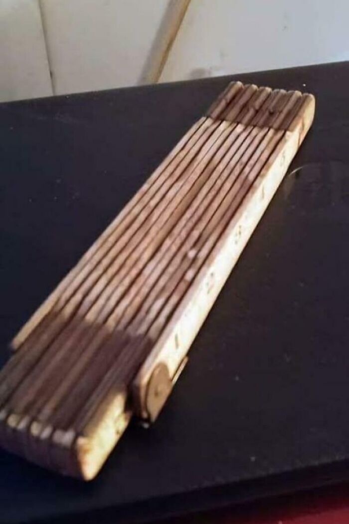 Wooden folding ruler on a dark surface, a nostalgic item from past decades in nostalgic photos collection.