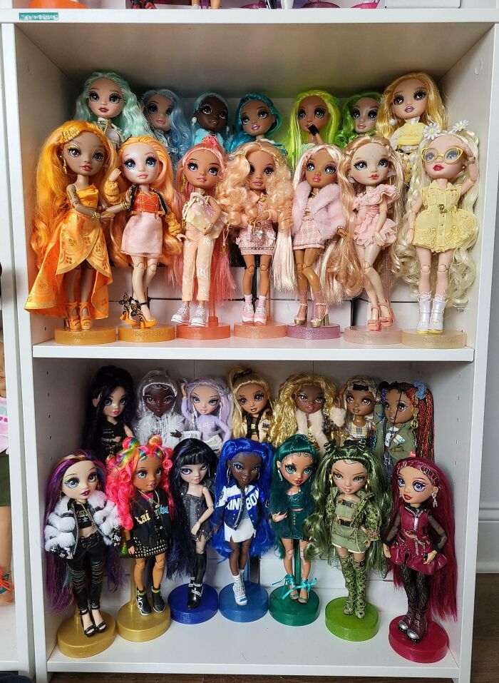 Shelf filled with an unusual collection of colorful fashion dolls, showcasing interesting and unique home collections.