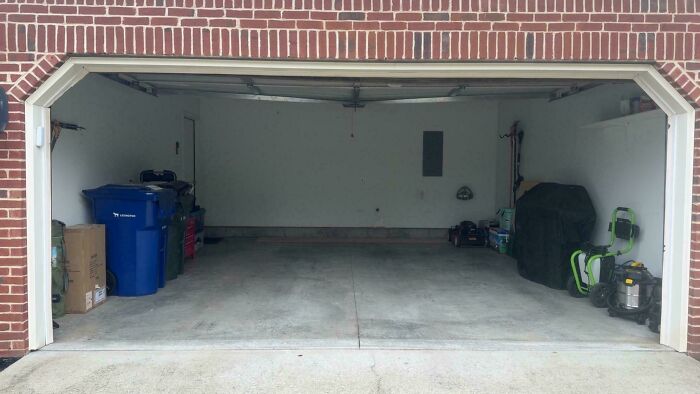 Empty residential garage with scattered items on sides, illustrating a mildly infuriated mood ruined by clutter and disorganization