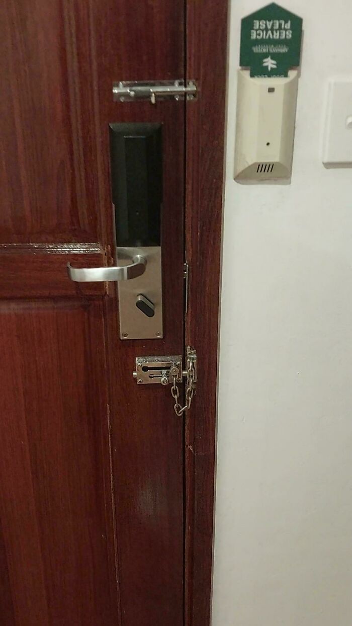 Hotel door with multiple locks including chain and bolt showcasing creative hotel design decisions for enhanced security.