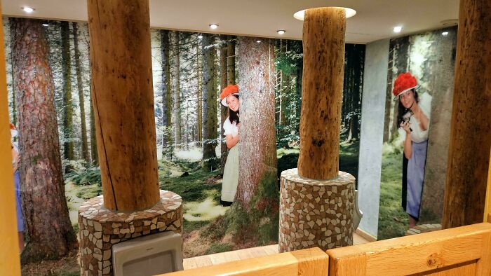 Hotel design with creative forest-themed wall murals and wooden columns for a unique guest experience.
