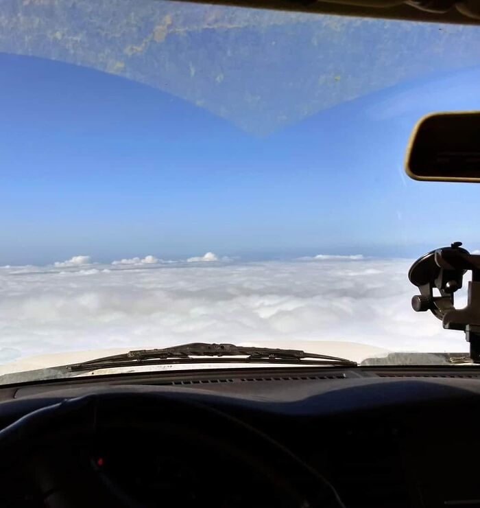 View from inside a vehicle showing clouds outside that look like the sea, an interesting thing requiring a double take to realize.