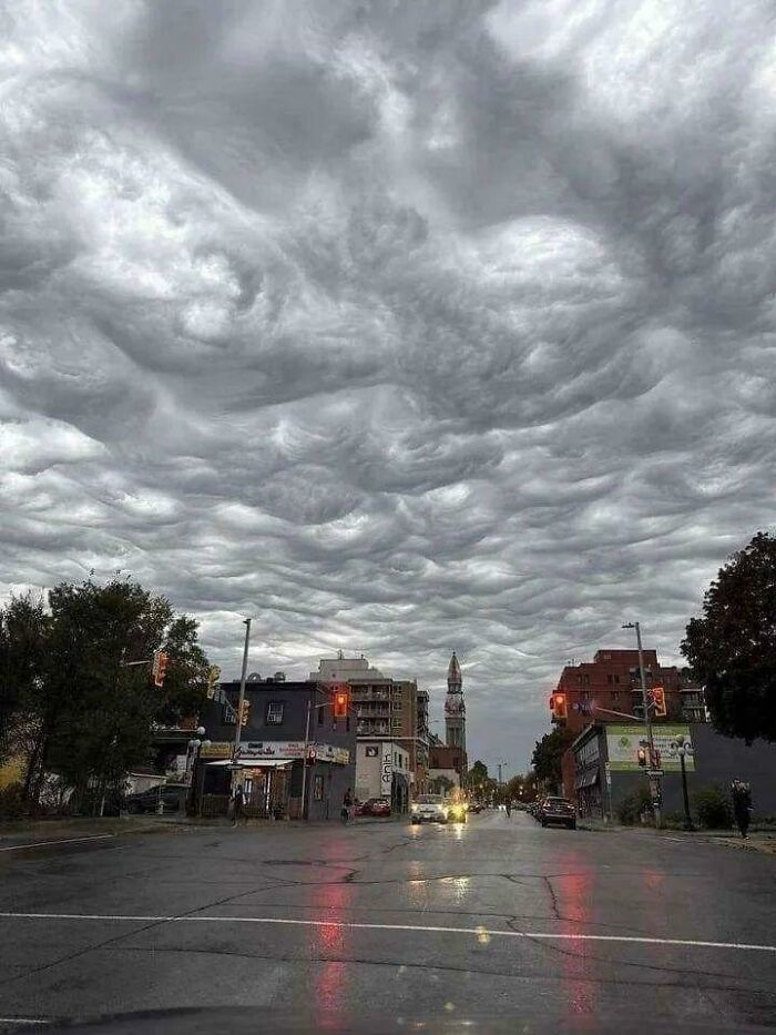 Unusual cloud formation resembling waves or ripples over a city street, an interesting thing requiring a double take.