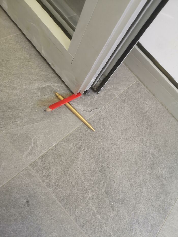 A door held open by two pencils acting as a DIY project that looks creative yet unhinged.