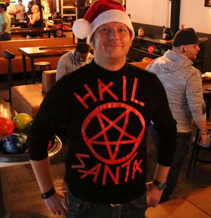 Man wearing a Santa hat and a creative DIY sweater with a pentagram design, showcasing unique DIY projects.