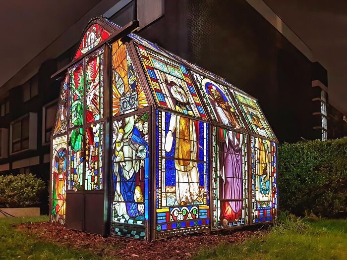 Stained glass DIY project greenhouse illuminated at night, showcasing impressive and creative homemade craftsmanship.
