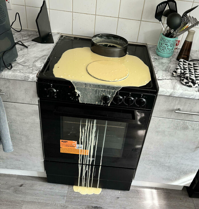 Batter spilled over a stove and dripping onto the floor, a cooking fail illustrating kitchen accidents.