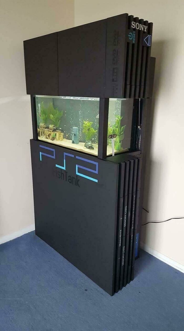DIY project transforming a PlayStation 2 console into a creative fish tank with decorations inside and plants.