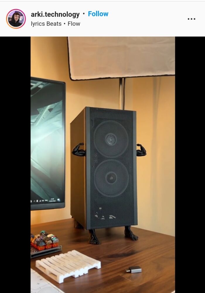 Speaker with DIY project legs and arms on a desk next to a computer monitor, showcasing creative DIY projects.
