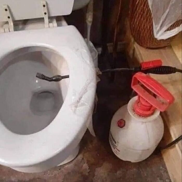 Toilet flush DIY project using a manual pump sprayer connected to the toilet bowl for unconventional flushing solution.