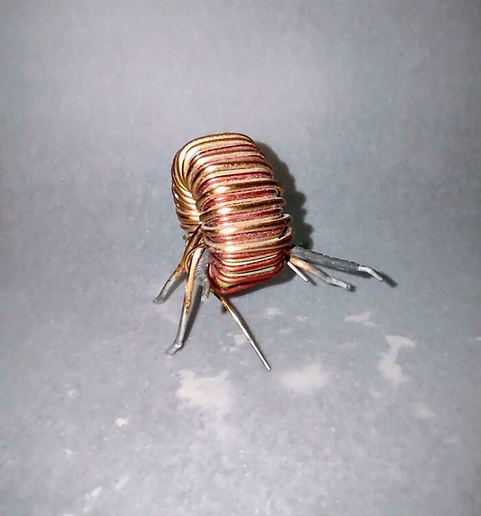 Copper wire coil crafted into a small insect-like figure, showcasing a unique DIY project idea.
