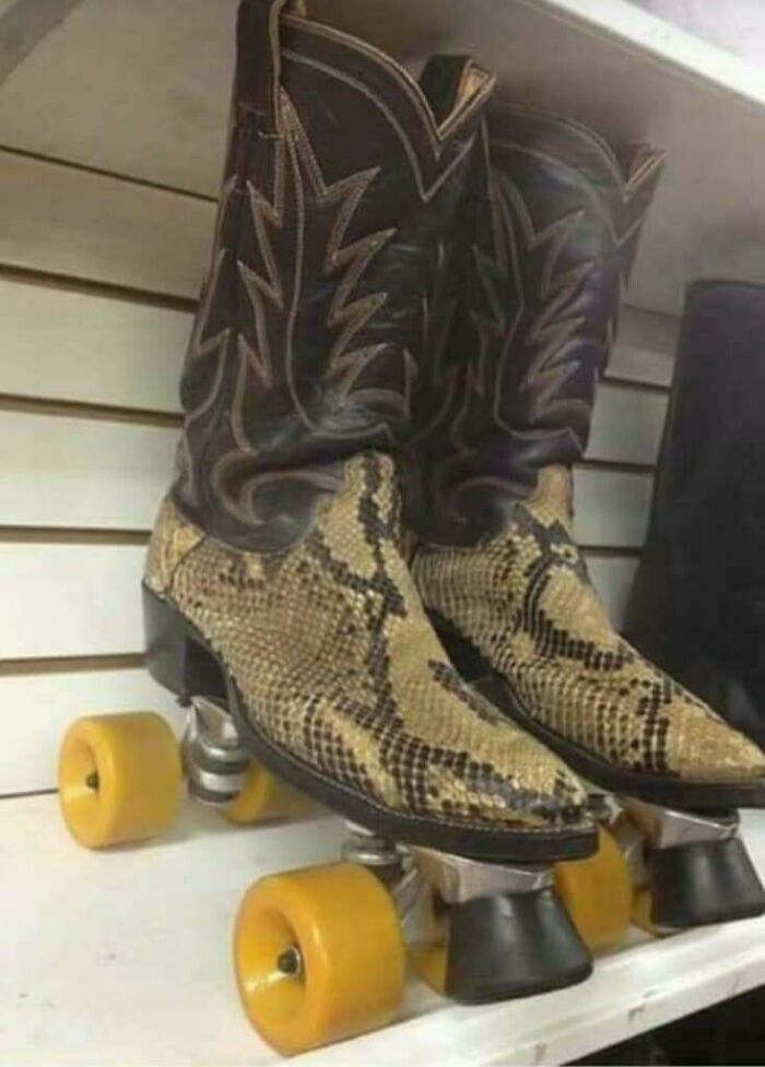 Pair of cowboy boots with snake print pattern modified into roller skates with yellow wheels on display shelf DIY project.