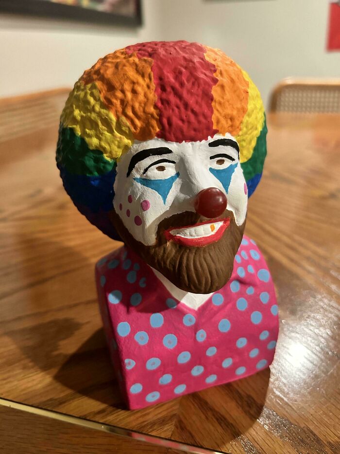 Colorful DIY clown bust with rainbow afro and polka dot shirt, showcasing a creative DIY project idea on a wooden table.